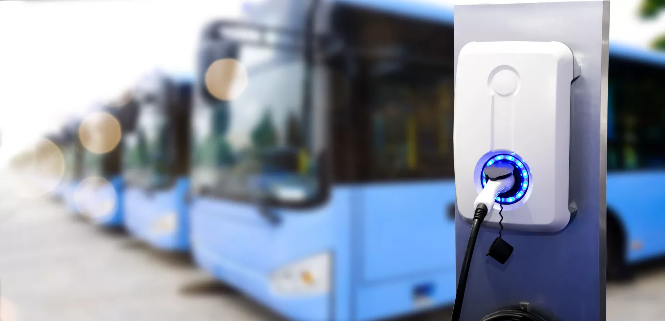 Power supply for electric car charging. Electric car charging station. Close up of the power supply plugged with lot of bus blur photo background