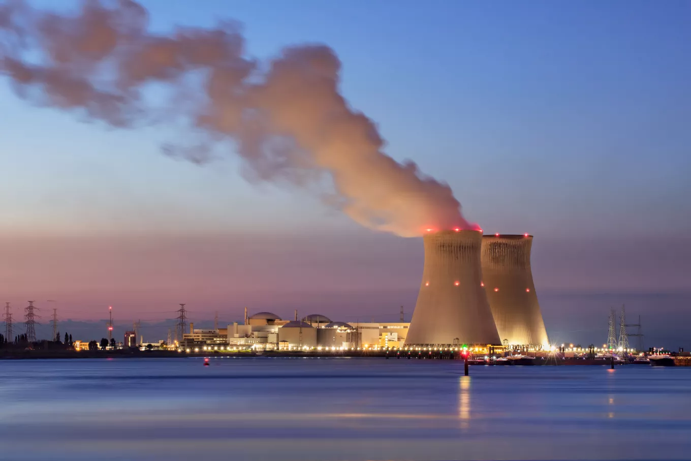 Riverbank with nuclear power plant Doel during a colorful sunset, Port of Antwerp, Belgium