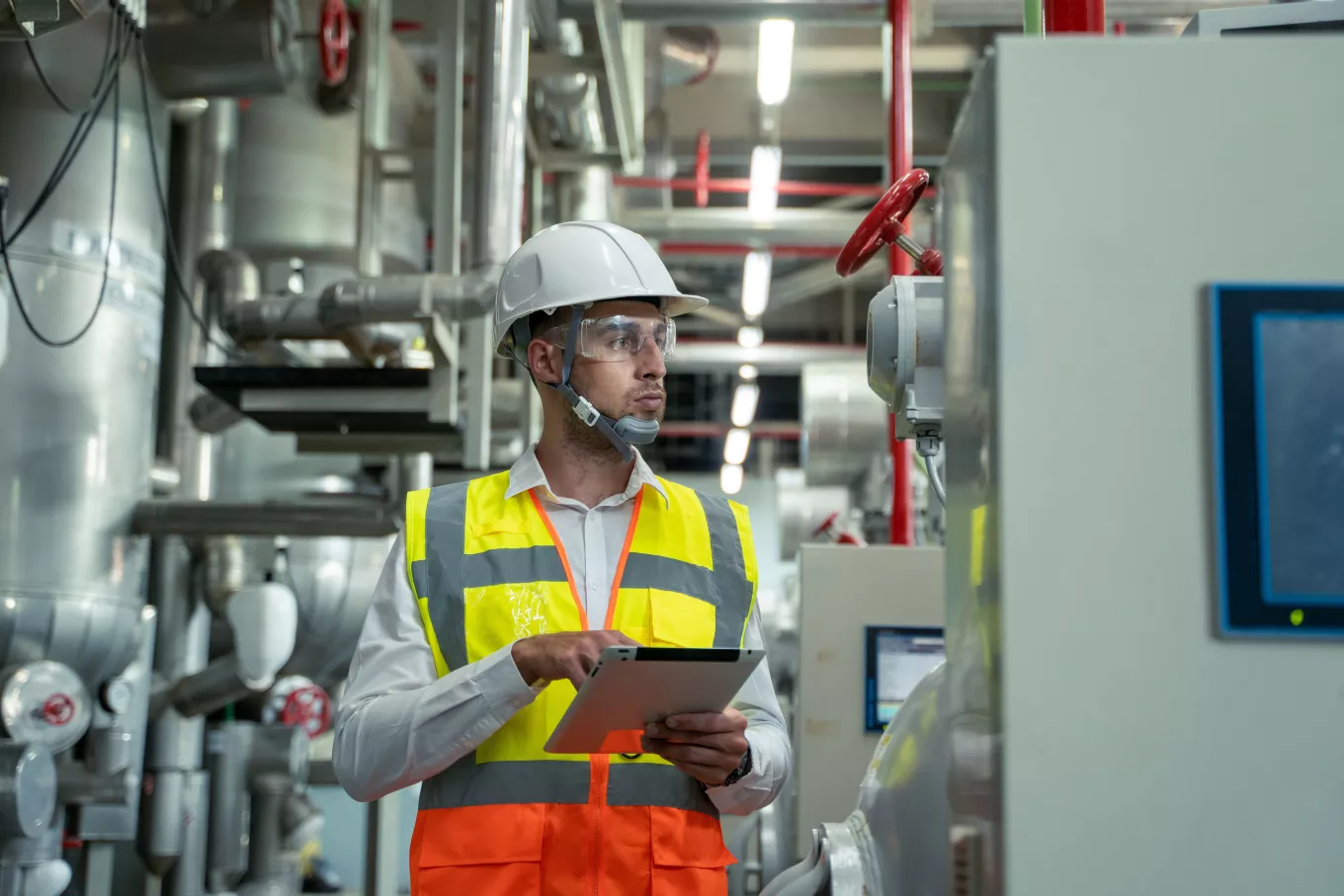 Engineer checking and maintenance technical data of system equipment condenser Water pump and piping air compressor system at manufacturing factory.