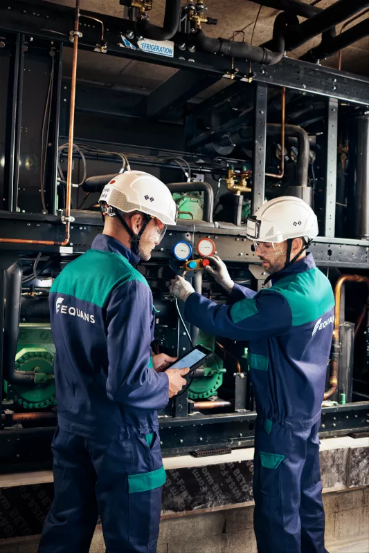 two workers in PPE working on HVAC