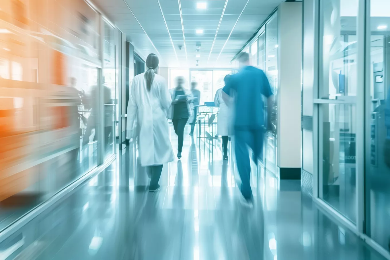 Blur motion of healthcare professionals and patient in hospital hallway, depicting busy medical environment and care.