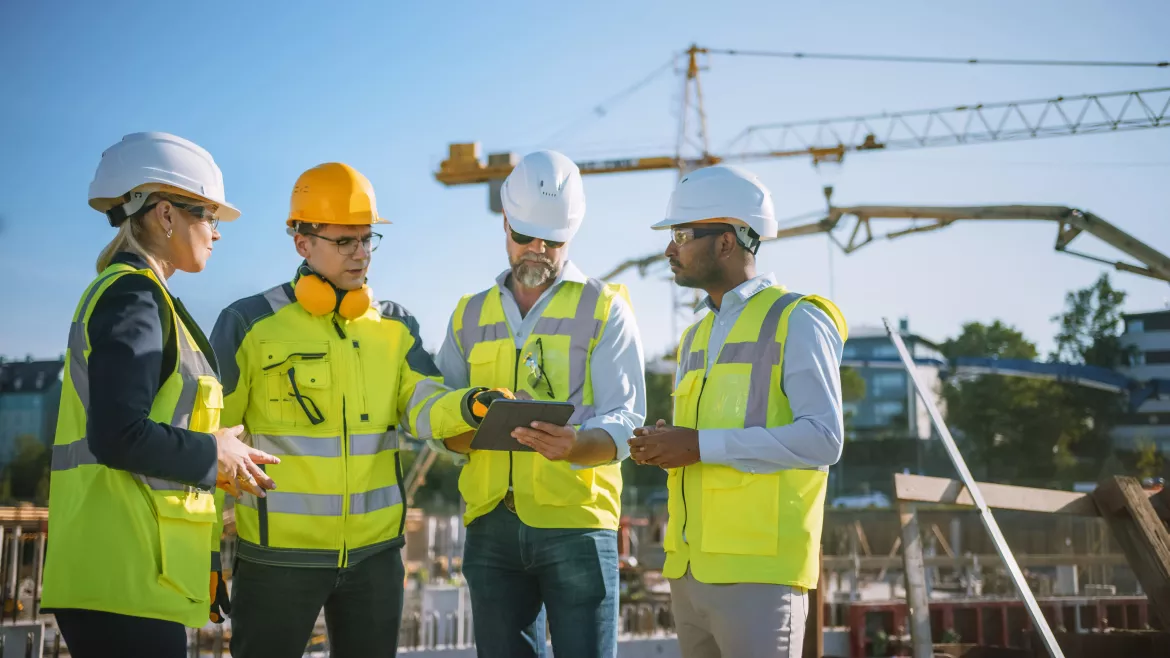 Diverse Team of Specialists Use Tablet Computer on Construction Site.