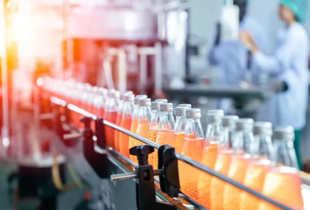 Drink factory production line fruit juice beverage product at conveyor belt.